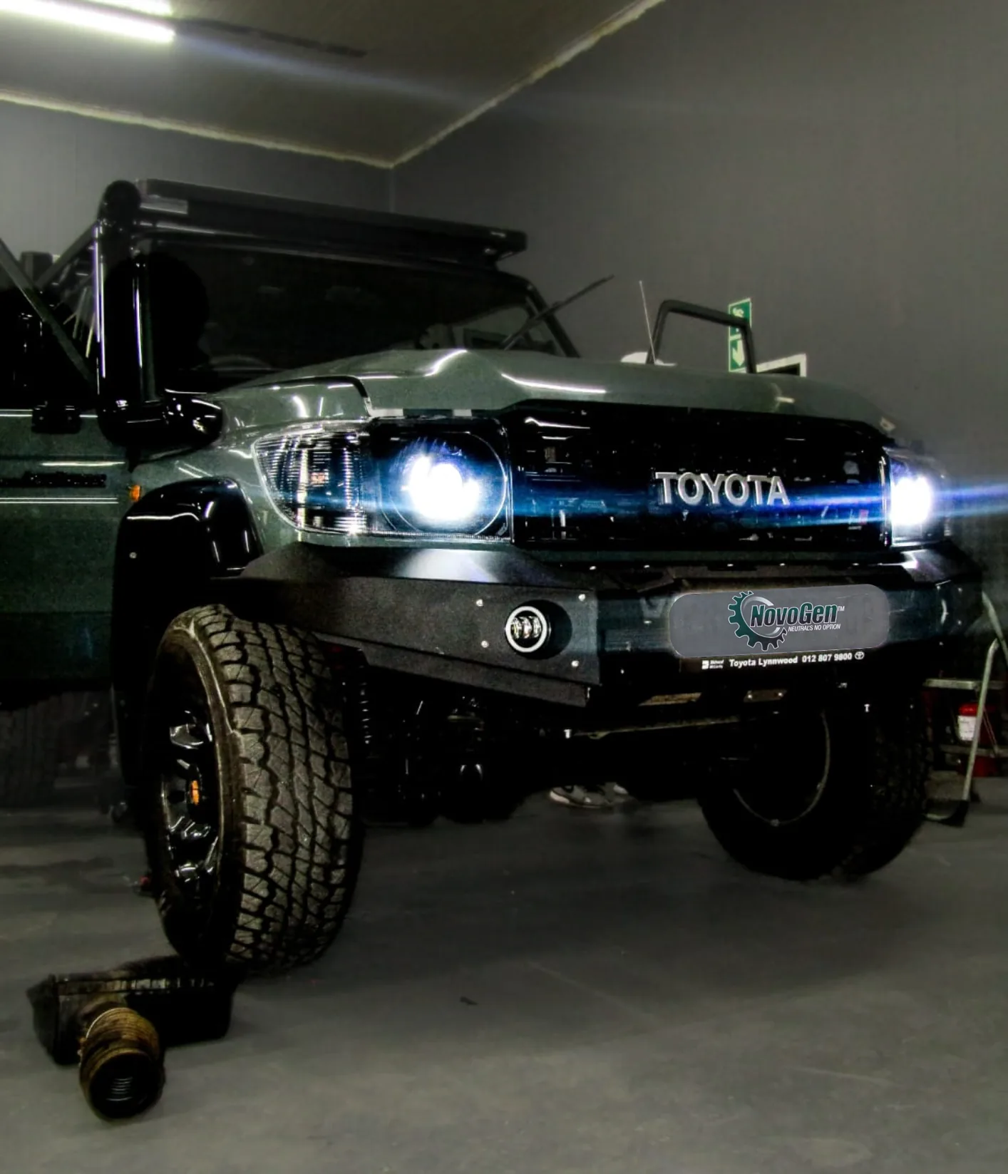 Novogen Land Cruiser with headlights on in workshop